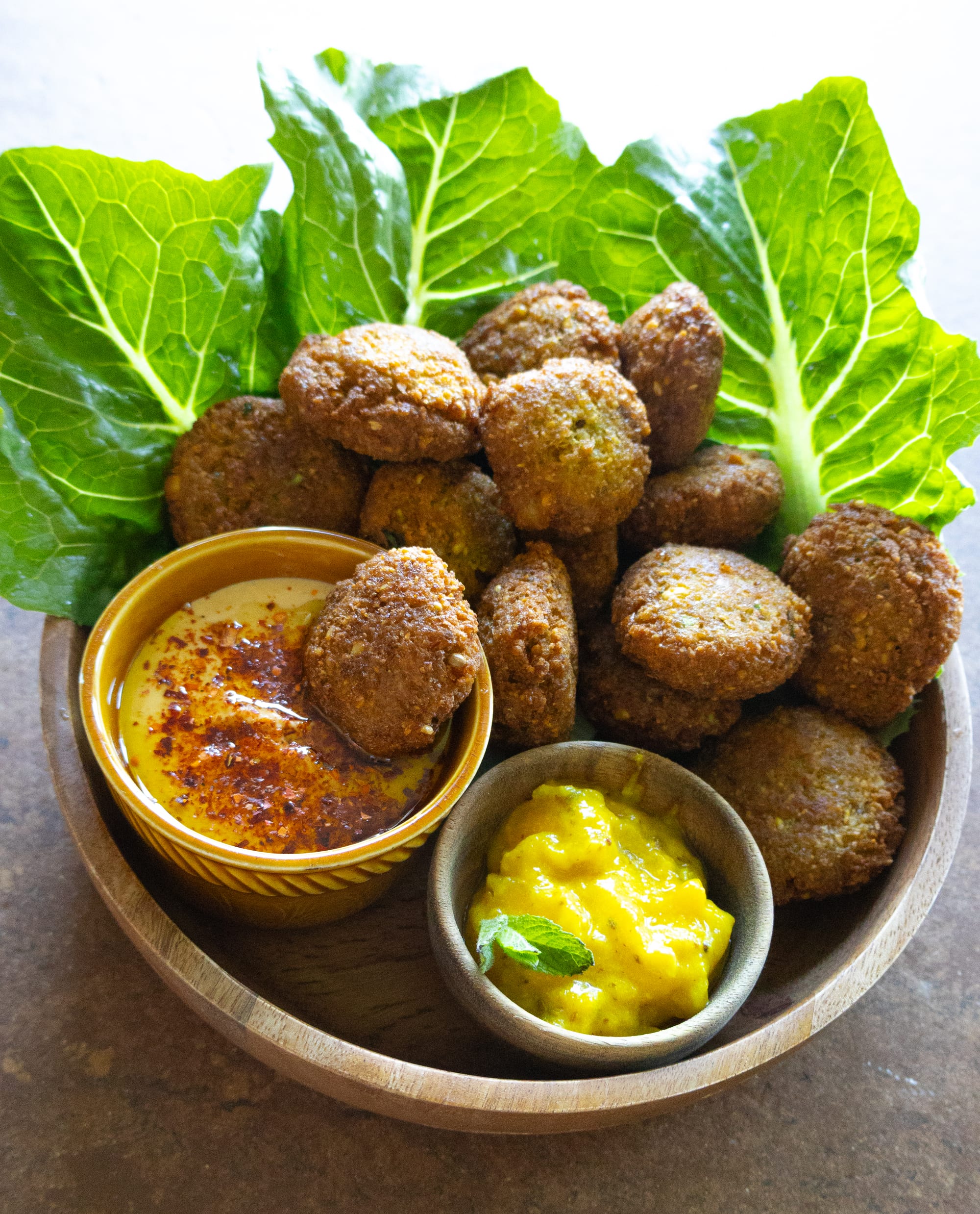 Schale mit selbstgemachten Falafel, Salat, Hummus und Mango-Dip