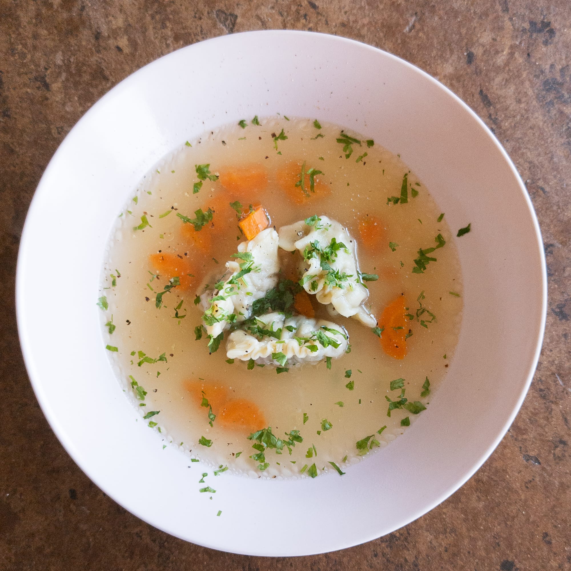 Suppenteller mit Hühnersuppe und selbstgemachten Salsiccia-Trüffel-Tortellini