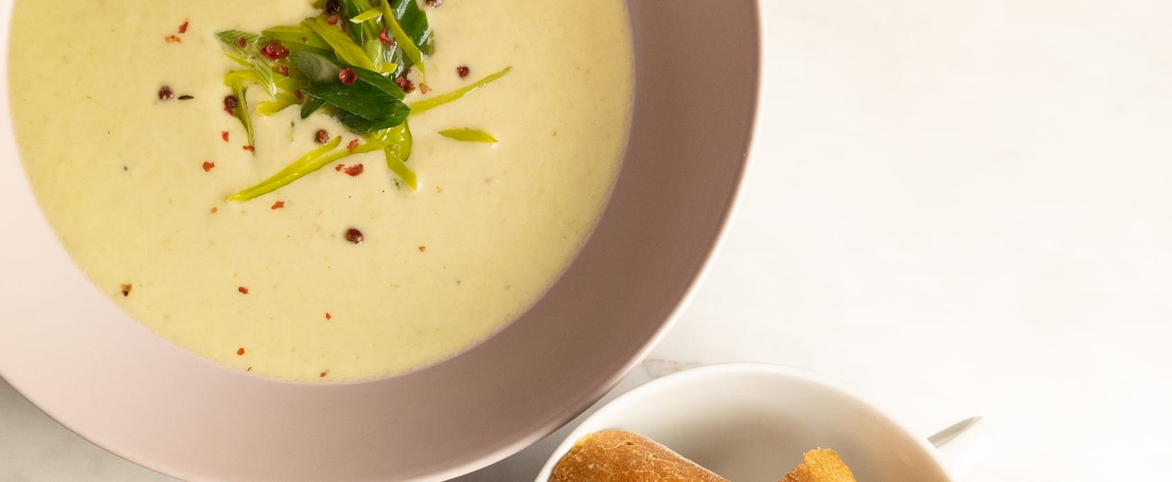 Lauchcremesuppe mit rosa Pfeffer dazu etwas Baguette