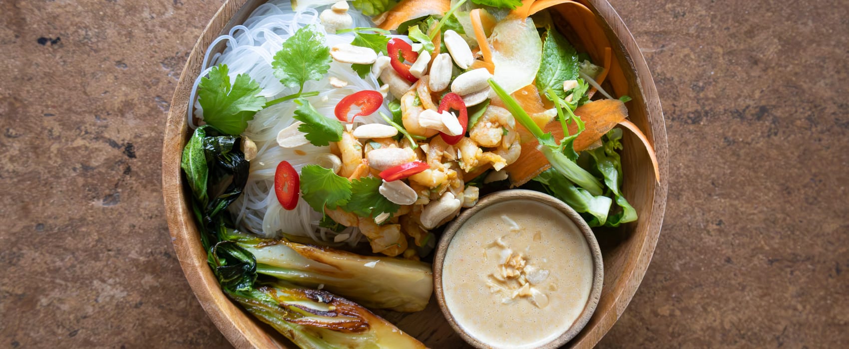 Schale mit Glasnudeln, asiatischen Salat und Erdnusssoße, garniert mit Chili und Erdnüssen